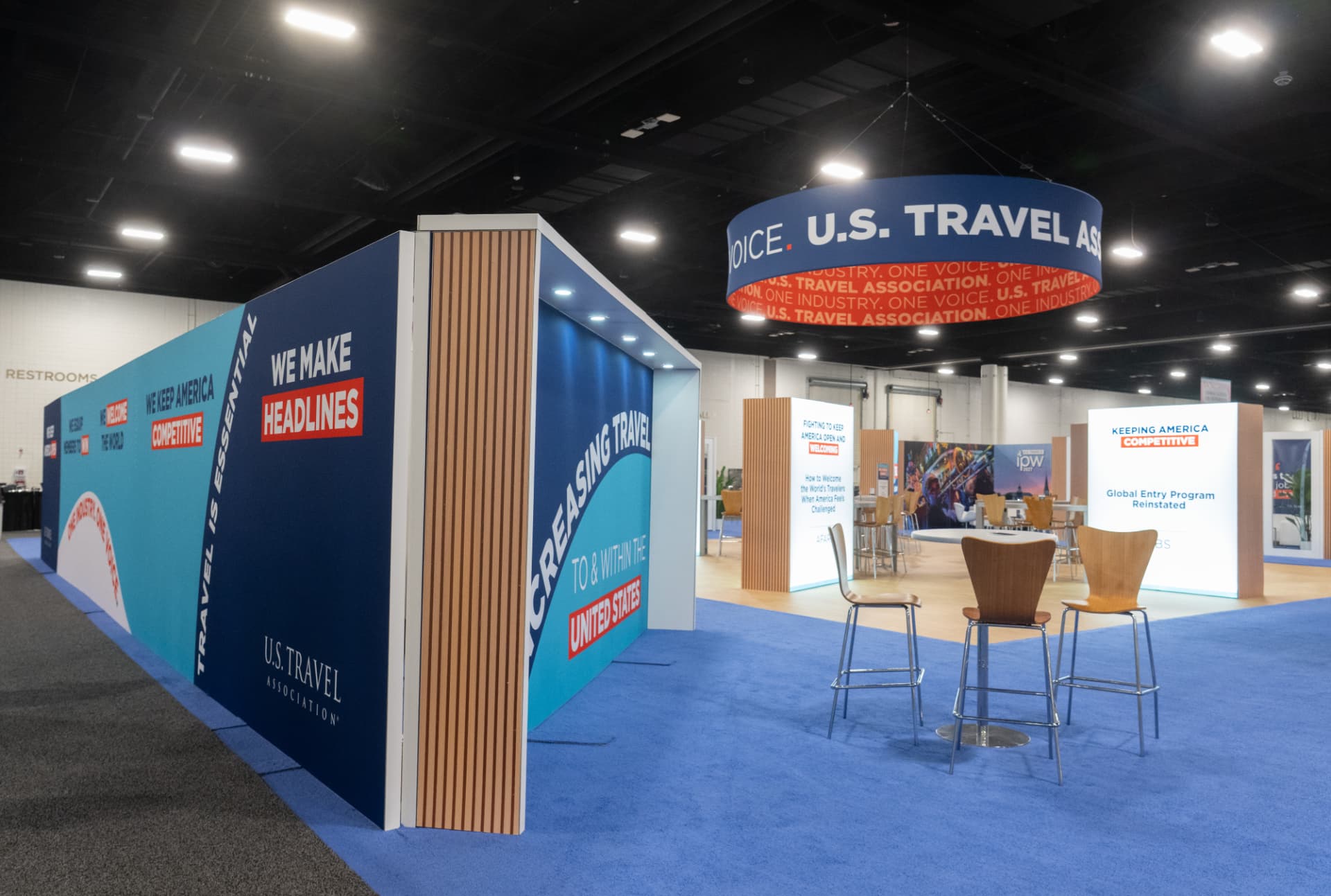 Wide view of the U.S. Travel Hub booth and hanging banner at IPW 2026